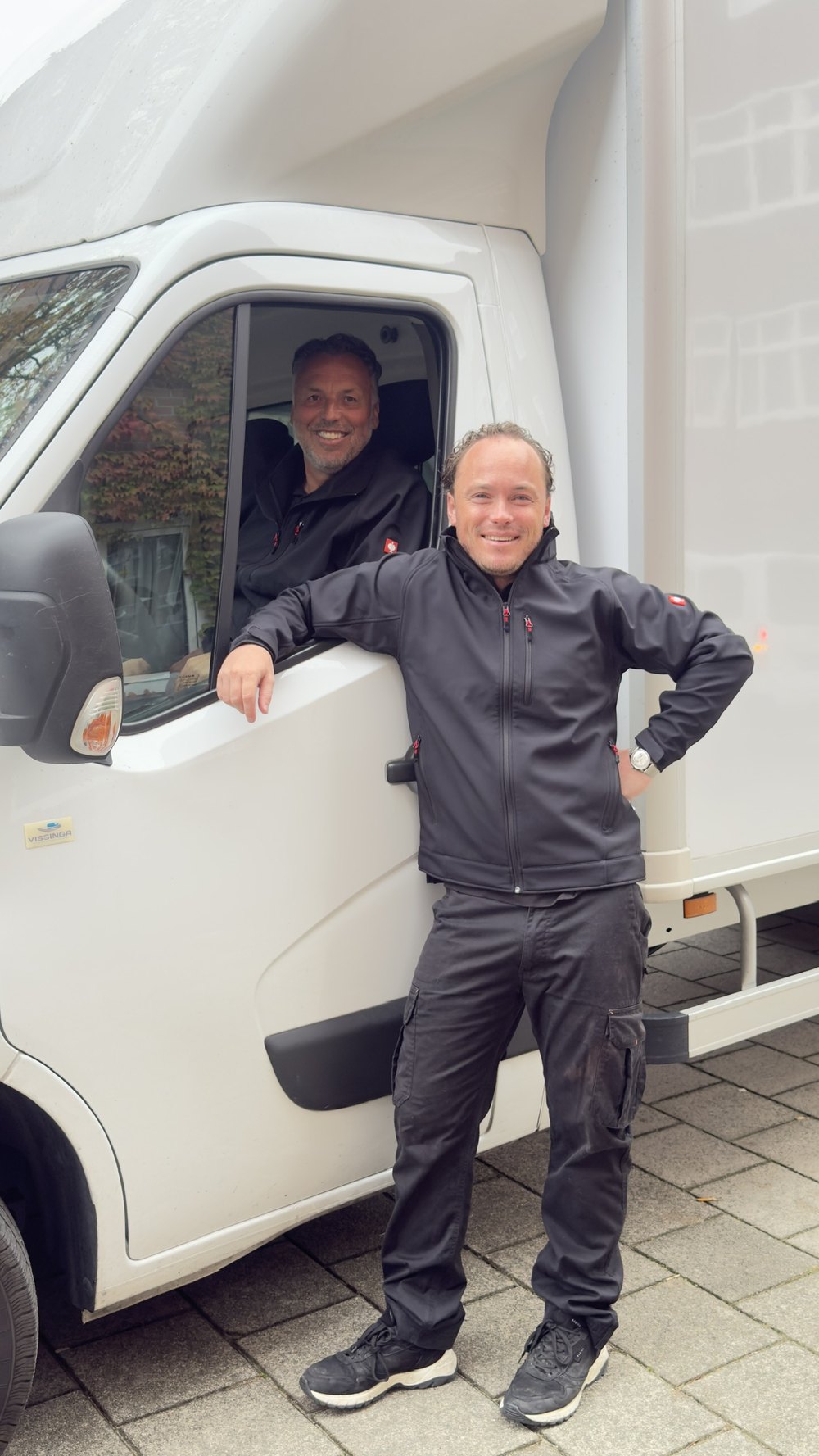 Dennis en Kevan bij de bus, Kevan ernaast en Dennis achter het stuur
